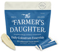 The Farmer's Daughter Daily Colostrum Essentials packaging with two travel sticks on a white background